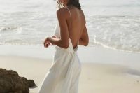 57 a minimalist flowy wedding dress with spaghetti straps and a sash plus a train for a modern or minimalist beach bride