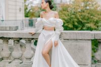 79 an exquisite and romantic bridal look with an off the shoulder crop top with a draped bodice, an A-line skirt with thigh high slit and a train