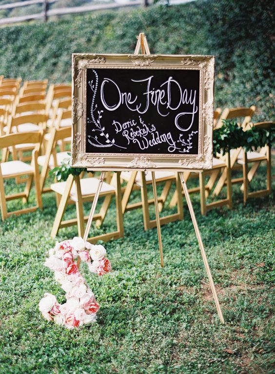 a beautiful and chic chalkboard sign in a refined gilded frame, on a stand and with a floral monogram is amazing