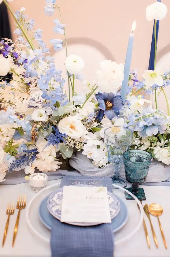a beautiful and inspiring garden wedding centerpiece with lilac, blue and white blooms and blue candles is amazing