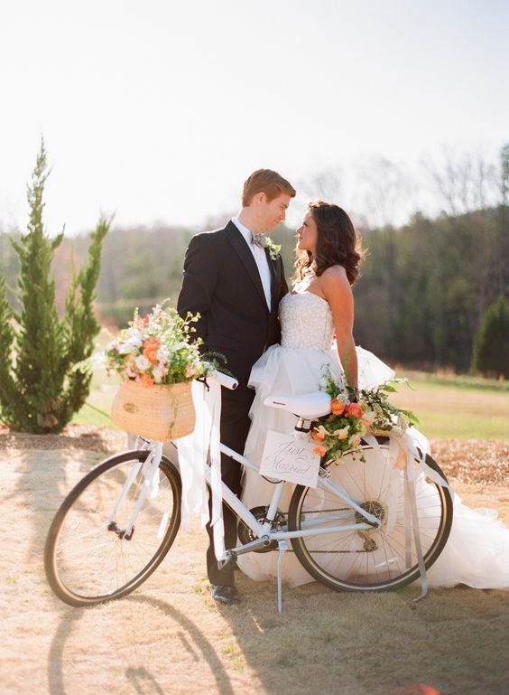 a beautiful white bike decorated with greenery, white and orange blooms and ribbon is a beautiful idea for summer