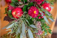 a bold fall wedding bouquet with burgundy blooms, apples and berries plus usual and dark foliage is a lovely idea for a rustic wedding