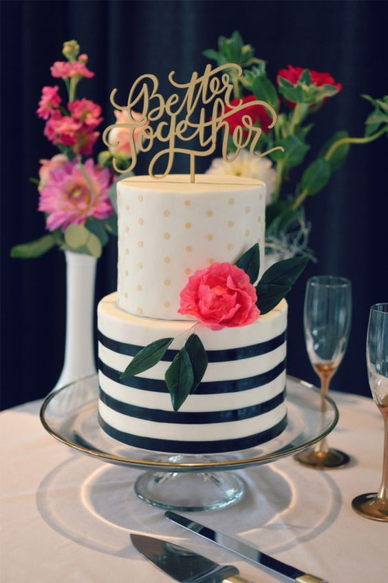 a catchy black and white striped tier and a gold polka dot one, with a bold bloom and a gold calligraphy topper