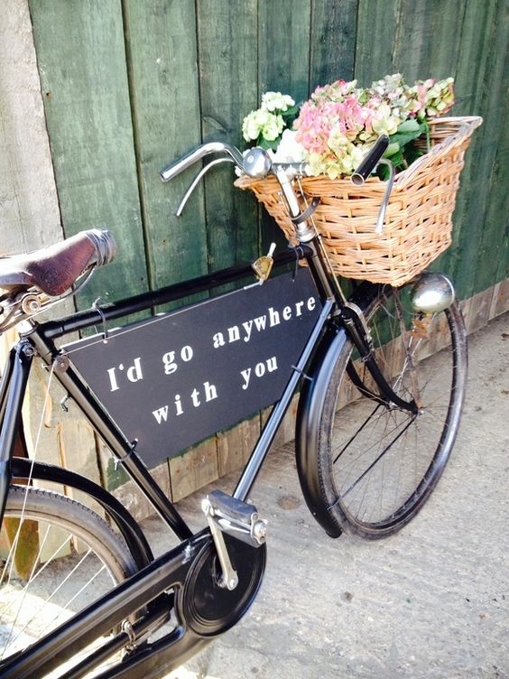 a chic black bike with a black sign and a basket filled with greenery and pastel blooms is a lovely decoration you can make