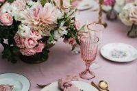 a chic garden wedding tablescape in rose, with beautiful and lush floral centerpieces, floral plates and pink glasses and linens