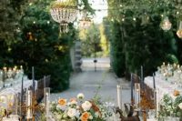a fantastic garden wedding tablescape done in rust and peachy tones, with tall white and navy candles, refined blooms and chic linens