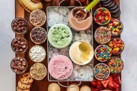 a gorgeous ice cream board with several types of ice cream, various toppings, cookies, waffle cones and much more as an alternative to a wedding dessert table