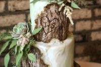 a gorgeous woodland wedding cake with greens, bark, fresh succulents and greenery looks really wow