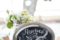 a mini chalkboard sign attached to a vintage silver tray and placed on a stand is a gorgeous idea for a rustic wedding