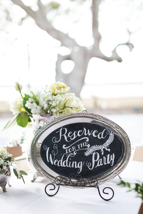 a mini chalkboard sign attached to a vintage silver tray and placed on a stand is a gorgeous idea for a rustic wedding
