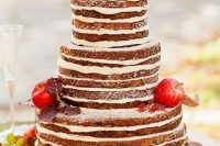 a naked wedding cake topped with leaves and fresh apples is a lovely idea for a fall rustic wedding