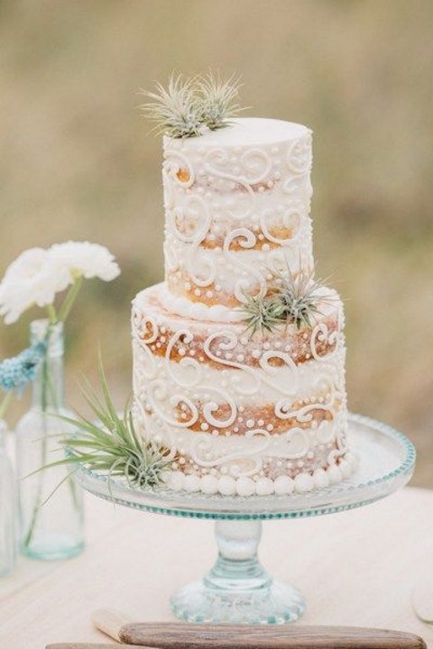 a naked wedding cake with cream decor and airplants is a great idea for a coastal or beach wedding