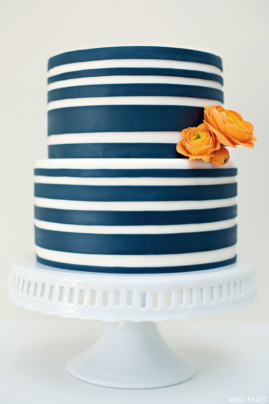 a navy and white striped wedding cake with orange blooms is a stylish idea for a nautical wedding is wow