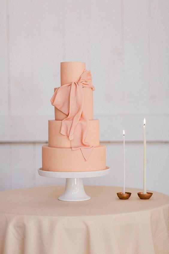 a peachy pink wedding cake with a matching sugar ribbon bow that looks like real ribbon is a lovely idea for a modern and bright wedding