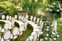 a refined garden wedding ceremony space with rows of white chairs, greenery and white blooms is amazing