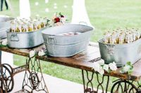 a refined vintage wedding drink bar of a Zinger machine stand and some galvanized bathtubs for storing drinks is a very cool idea to rock