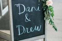 a rustic chalkboard sign  on a vintage stand, with greenery and neutral blooms is a lovely idea for a rustic wedding, and you cna easily DIY one