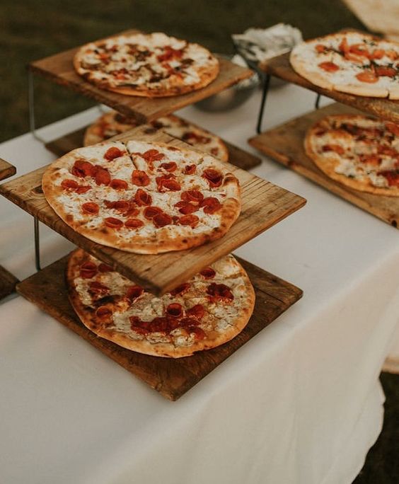 a rustic pizza bar with pizzas on wooden stands is a very simple and cute idea