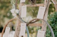a rustic seating plan of a ladder, old metal wheels with blooms and the seating plan is a cool idea for a wedding