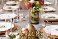 a simple fall wedding centerpiece of a silver tray with apples, pears, greenery and mushrooms is a creative idea for a rustic celebration