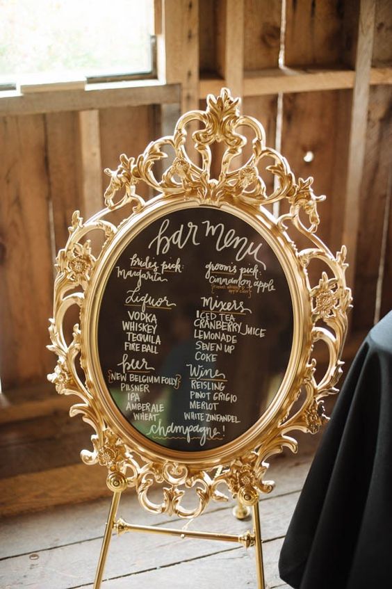 a sophisticated chalkboard sign in a refined and chic gilded frame is a lovely idea for a vintage wedding or a refined modern one