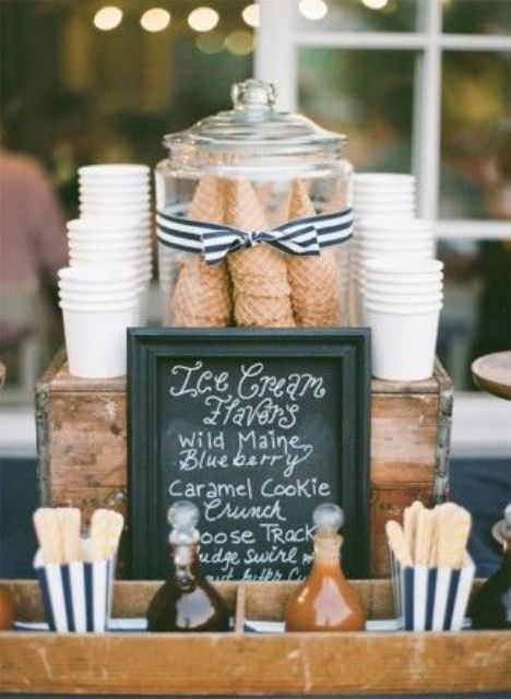 a stand with paper cups, waffle cones in a jar and some toppings and sticks for your ice cream is great for a vintage wedding