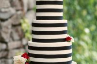 a striped black and white wedding cake decorated with neutral, red and burgundy blooms and greenery is a bold and contrasting idea