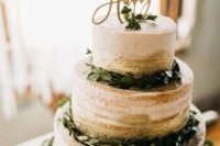 a stylish naked wedding cake with gold leaf, greenery and an elegant topper for a modern wedding