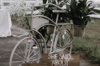 a stylish white bike with plaque signs, baby’s breath and greenery in baskets is a lovely decor idea for a relaxed wedding