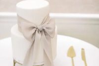 a stylish white wedding cake decorate with a dove grey ribbon bow is a very refined and beautiful solution for a modern and exquisite wedding