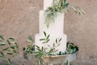 a stylish white wedding cake with olive greenery and olives for a Tuscany or Italian wedding