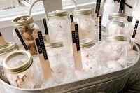 a tin bathtub filled with ice and with jars with ice cream plus some sticks is a very fresh and simple idea to serve ice cream at a rustic wedding