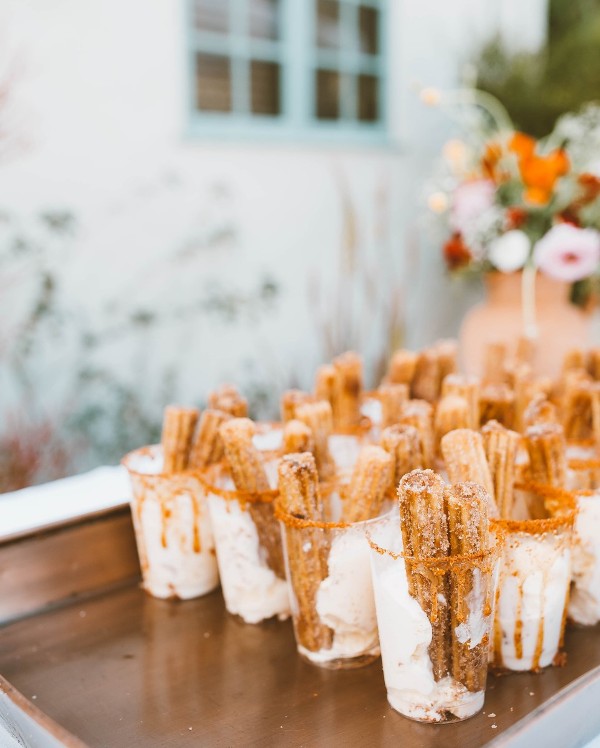 a tray with glasses with ice cream and fresh churros is a lovely and inventive idea to serve ice cream