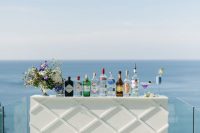 a very laconic and chic modern drink bar with a plaid pattern and a gorgeous sea view is an ultimate idea for a modern or minimalist wedding