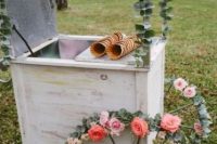 a vintage ice cream trolley with flower-covered wheels and greenery is a lovely idea for a relaxed and laid-back wedding