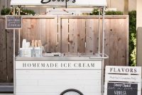 a vintage white ice cream trolley with a pompom banner, with ice cream cones and a little menu is a classic idea for any wedding