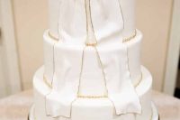 a white buttercream wedding cake with a sugar bow, with gold beads is a pretty and fun idea for a modern wedding in neutrals