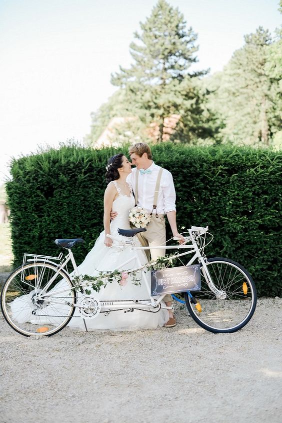 a white double bike with greenery and blooms and a chalkboard sign is a lovely idea for a wedding, if you love riding a bike