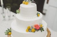 a white textural buttercream wedding cake with billy balls and pink roses, greenery and bike cake toppers is a lovely idea