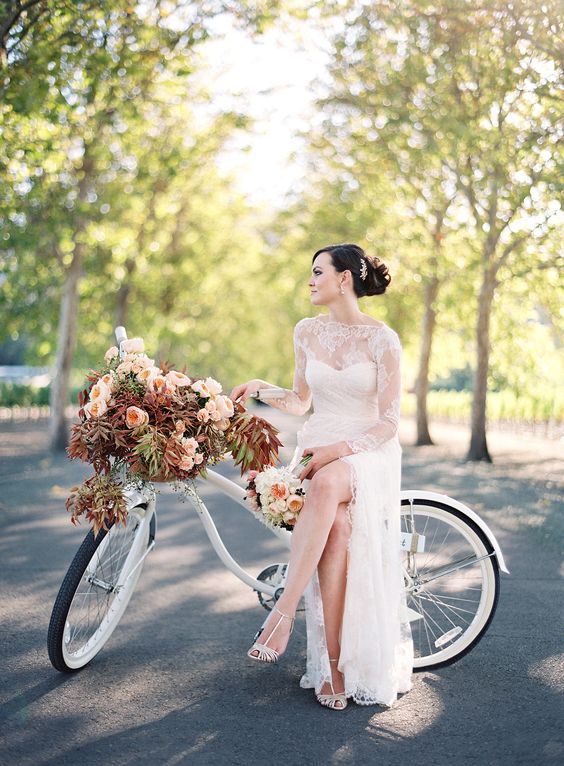 an elegant white wedding bike decorated with pink blooms and bold foliage is a beautiful idea for a fall wedding