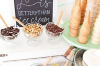 an ice cream station with a chalkboard sign, waffle cones and some pretty toppings is a classic idea for any wedding