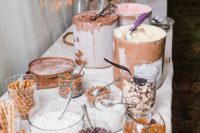 an ice cream table with lots of toppings, waffles and several types of ice cream in very large jars is perfect for a wedding