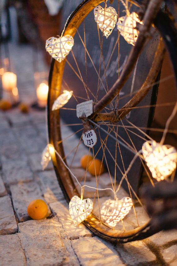 an old metal wheel decorated with lovely twine heart garlands is a pretty and easy decoration for a relaxed wedding