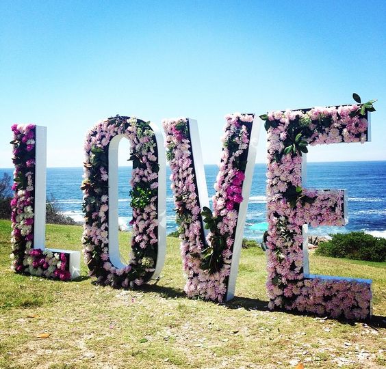 giant pink floral love letters as a wedding ceremony backdrop
