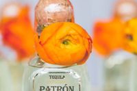 mini tequila bottles decorated with bright orange blooms are great for Mexican wedding