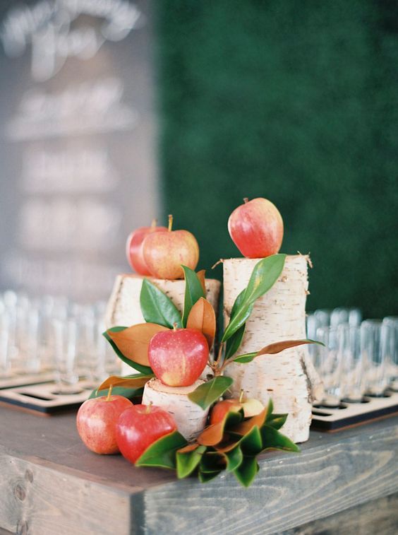 pretty and easy rustic wedding decor of tree stumps, magnolia leaves and apples is amazing for a simple fall wedding