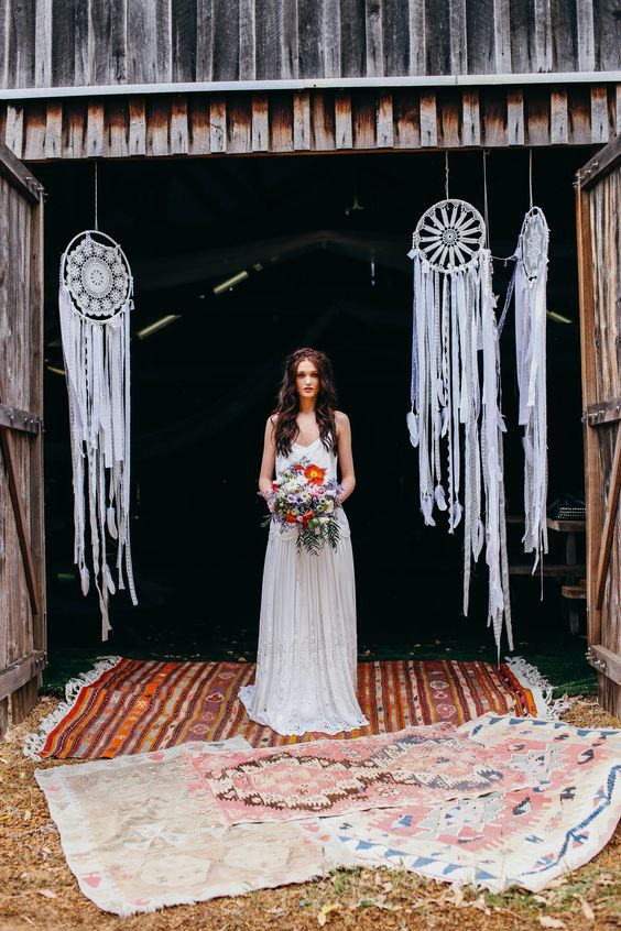 White lace dream catchers with long lace fringe and feathers hanging down to make the space more boho like