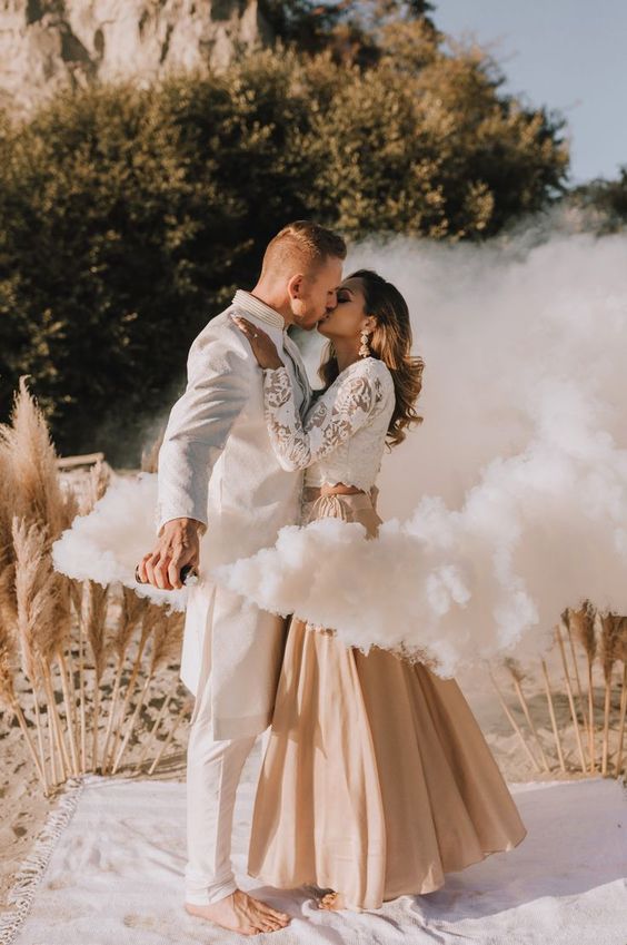 a boho beach wedding portrait with pampas grass and some smoke looks ethereal and beautiful
