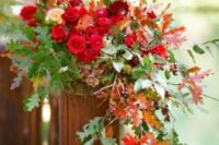 a bold fall leaf arrangement with bright and blush blooms and green and colorful leaves is amazing for a fall wedding ceremony space