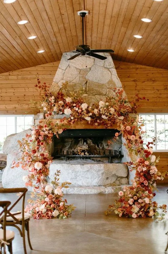 a bright fall wedding arch decorated with bold leaves, white, blush and burgundy blooms and twigs is a lovely idea